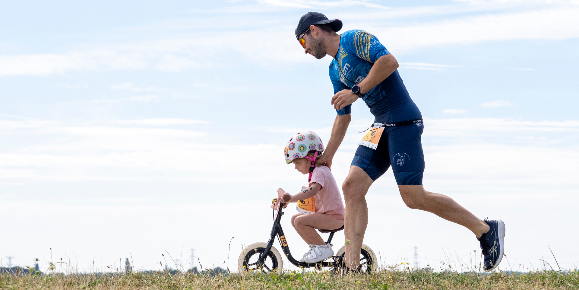 Ouder loopt mee met kind op loopfiets