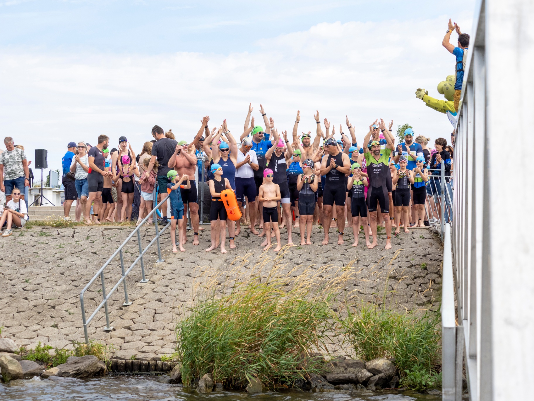 Deelnemers staan klaar aan de waterkant voor de start van de Maastriatlon